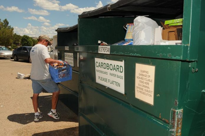 Ed McAnally takes care of his weekly recycling chore in a shopping plaza parking lot on Finnie Flat Road on Sunday, Aug. 8.