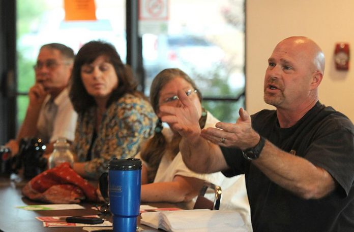 Jay Pond, right, the owner of a local pet store which frequently hosts adoptable Verde Valley Humane Society felines, questions the short hours the animal shelter keeps at the shelter’s annual board meeting Friday, Sept. 17. The shelter is currently open to the public 26 hours per week usually between 10 a.m. and 3 p.m., hours Pond said are inaccessible to most working people.