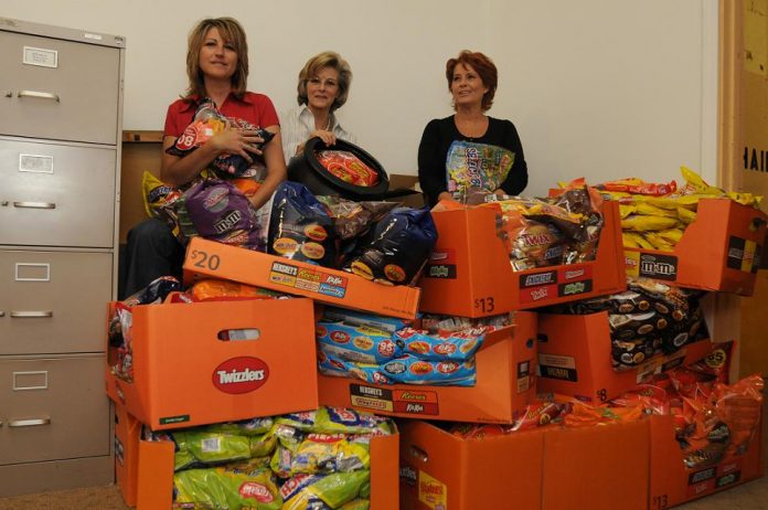 Camp Verde town employees, from left, Valerie House, Deborah Ranney, and Lynda Moore, sit amid pounds of donated candy Oct. 20. The candy will be distributed to local children during the town’s Main Street trick-or-treating event Sunday, Oct. 31.