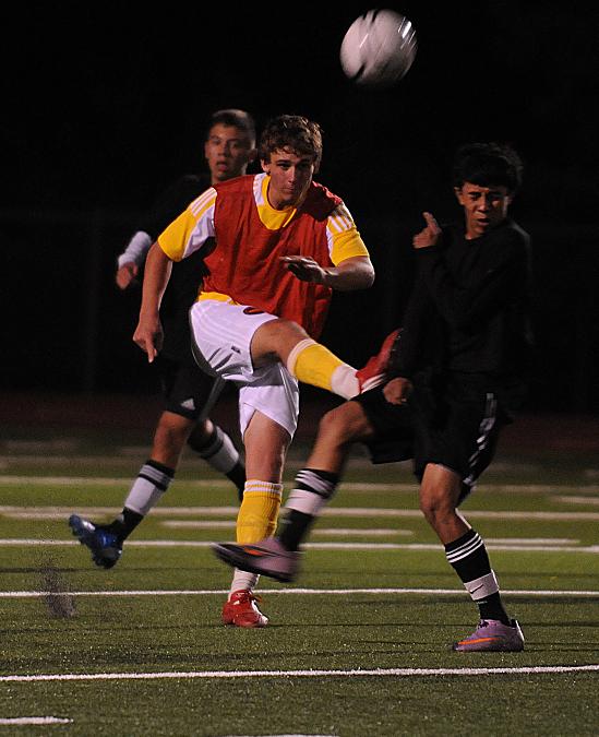 Sweeper Jonathan Witt pops the ball back downfield against North Canyon High School on Nov. 17.