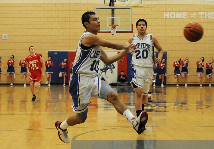 Andres Orellana passes to a teammate during a home game against Mingus Union High School on Friday, Dec. 17. The Cowboys delivered a decisive 51-35 point victory over the Marauders.