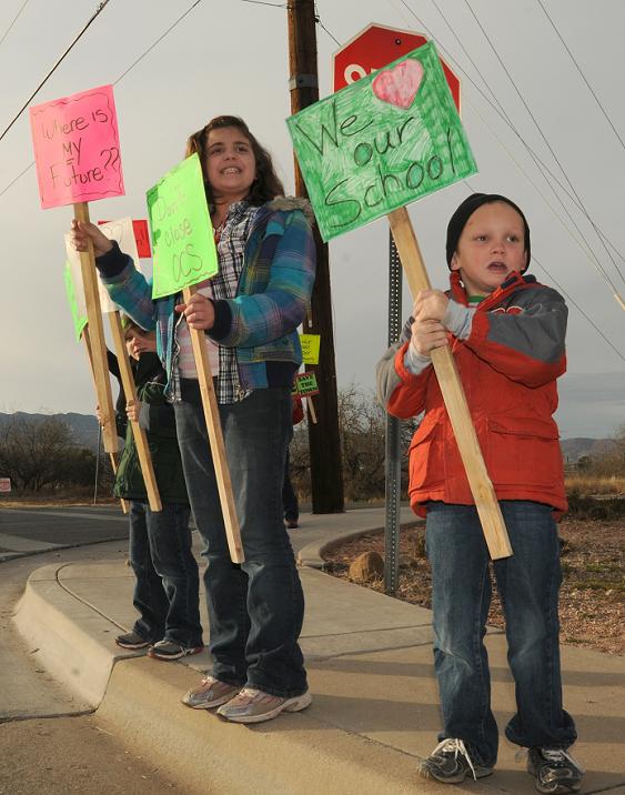 Young demonstrators, from left, Hunter Cowgill, 5, Faye Richey, 10, and Ethan Cowgill, 5, protest against the potential closure of Oak Creek School before the start of a Cottonwood-Oak Creek School District work session and board meeting Jan. 11. The school board decided to send out 30-day notifications to those directly affected by the possible closure of both OCS and Tavasci Elementary School as a way to close a $1.5 million budget gap.