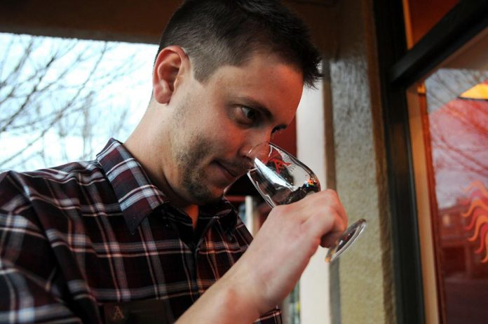 Kevin Grubb, an assistant tasting room manager, collects a soil sample for a presentation on common aromas and flavors of wine Friday, Feb. 18.