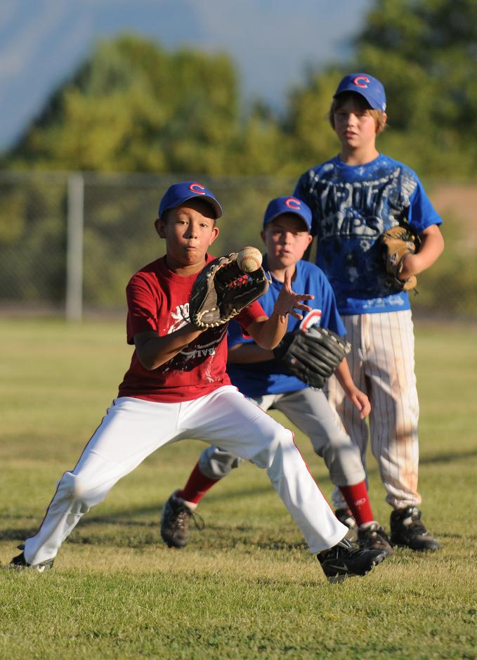 Camp Verde Little League All-Stars from the 10- and 11year-old players team, from left, Jordan Huey, Zack Wester and Ryan Loza practice catching grounders during practice at Butler Park on June 15.