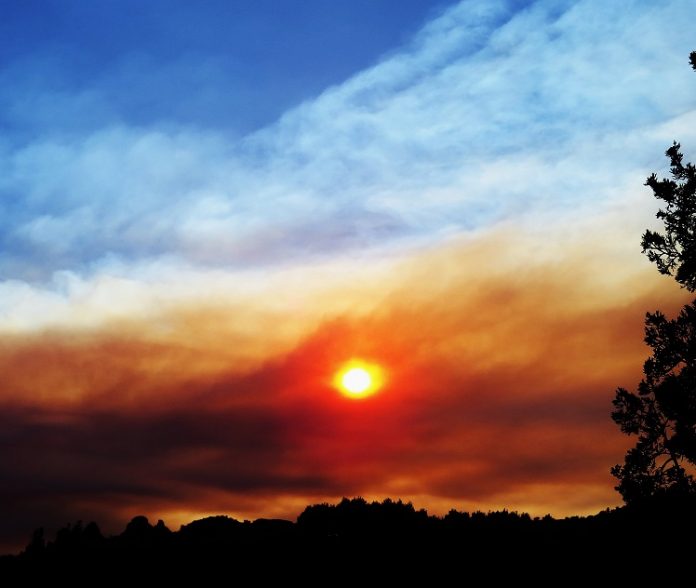 The sun sets behind clouds from the Doce Pit Fire drifting over the Verde Valley. This photo was shot near Red Rock Crossing.