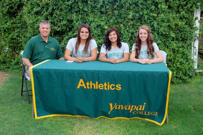 Yavapai College Athletic Director Brad Clifford, left, prepares Torey Gillies, Angelina Saucedo and Bailey Mabery to sign their National Letters of Intent to play softball for the Yavapai College Roughriders. The three former Marauders are part of a 10-player recruiting class for the Division I NJCAA program that finished its past season 36-19 and made a sixth consecutive post-season appearance.