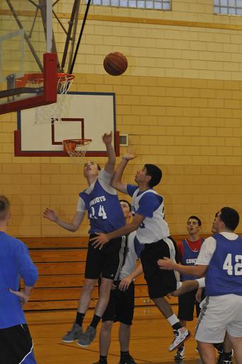 Players vie for position under the basket during a Cowboys basketball practice.