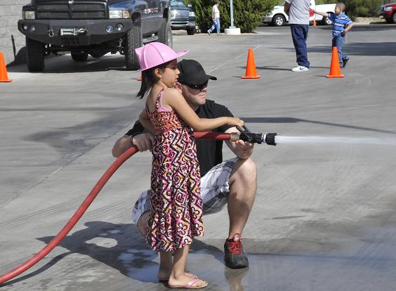 Engineer Cody Harkey, of Fire Station No. 32, helps Aylene Sotelo, 6, knock down some cones with a fire hose. The Verde Valley Fire Foundation held a pancake breakfast fundraiser on Saturday, May 17, at Verde Valley Fire Station No. 31 in Cottonwood. The proceeds will help the Verde Valley Fire District get new equipment. Activities were set up for the kids to give them a peek into the lives of firefighters.