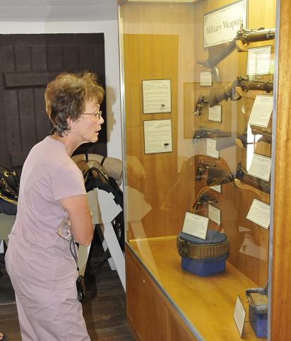 Jeannie Litwin, of Surprise, peruses the rifles stored within Fort Verde on Sunday, June 8. The fort is a Heritage site, for which Camp Verde is currently trying to get more funding.