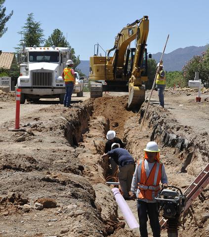 A construction crew from contractor Alliance Street Works, out of Camp Verde, busily works on the 12th Street Improvement Project. Part of the project is installing an eight-inch reclaimed water line, which is color-designated purple.