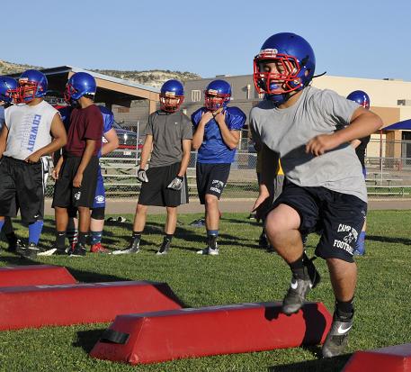 The Camp Verde High School football team is hoping underclassmen like freshman Bryce Garcia can contribute this fall. Garcia puts his legs through their paces in an agility exercise that’s punctuated with a tackle at the end.