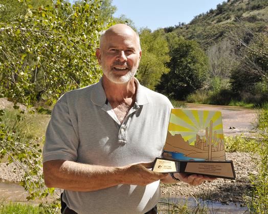 Clarkdale Mayor Doug Von Gausig stands on the bank of the Verde River with the Crescordia award the town recently received. The award was given to the town for Environmental Stewardship, part of the 2014 Environmental Excellence Awards, for its Verde River@Clarkdale project.