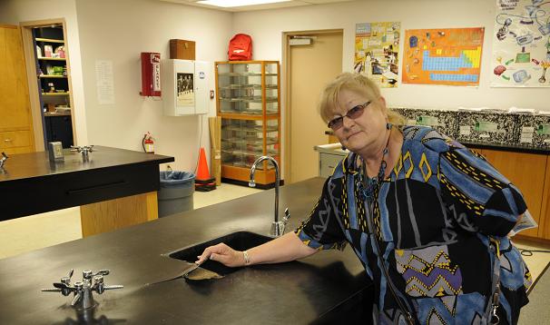 Denise Kennedy, principal of Cottonwood Middle School, gives a tour of the school, demonstrating why the school needs capital for repairs and improvements. Here, Kennedy lifts the peeling countertop in the science lab.