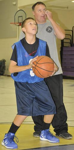 Seventh-grader Drew Meyer, of the Mountain View Prep basketball team, lines up a free throw during practice with coach Troy Hoke looking over his shoulder. Mountain View got its first win of the season Tuesday, Nov. 17, with a 30-16 win over Big Park Community School.