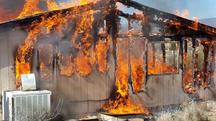 An abandoned house engulfed in flames burns at temperatures reaching 1900 F. The house was donated to the Verde Valley Fire District to use for live fire training, and then burned down so the property could be built on anew. Live fire training gives firefighters invaluable experience in a controlled setting.
