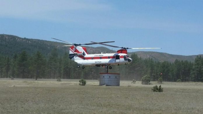 With a capacity of 15,000 gallons, a helicopter fights the Cedar Fire from the sky. Two members of the Verde Valley Fire District were dispatched to the fire, charged with making sure there was enough water for the helicopter.