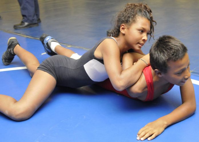 Rowen Wolfe, 11, top, wrestles with her brother Caiden, 10, during practice, nearly getting him into position to be pinned. The siblings both wrestle for the Camp Verde wrestling club New Breed at Weekend Wars.