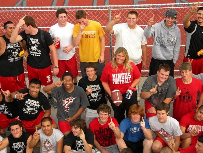 Candi Yatsinko stands Monday, Dec. 6, with members of the Mingus Union High School football team, who she calls “her boys.” Yatsinko was voted Goodwill of Central Arizona Football Mom of the Year.