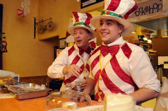 Smitty Smith, left, and Michael Galatioto greet Chocolate Walk guests with smiles and homemade candy at an Old Town restaurant Saturday, Dec. 4.