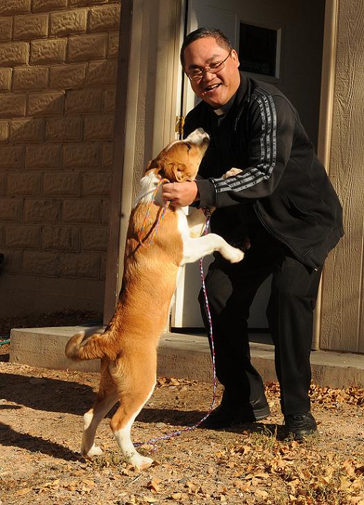 The Rev. Reynaldo Clutario visits with a puppy available for adoption and currently being housed at the Camp Verde Animal Shelter on Thursday, Dec. 2. The St. Francis Cabrini Parish priest will perform an animal blessing at 1 p.m. on Sunday, Dec. 12, in the New Thrift Store parking lot.