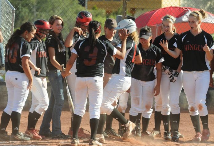 Mingus Union High School softball players welcome teammate Cassie Norman, fourth from right, to home plate after she hit one over the fence during a home game against Shadow Mountain High School on Tuesday, May 3.