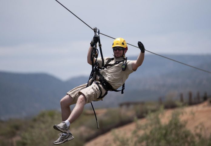 Tyler McCallum, a zip line guide, heads into a tower at Out of Africa Wildlife Park. The Predator Zip Line had its grand opening on Saturday, June 15, in Camp Verde. The five zip lines carry passengers over lions, tigers, zebras and giraffes.