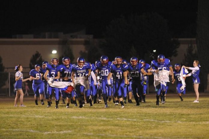 The Camp Verde football team runs on the field before their homecoming game against Sedona Red Rock.