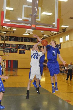Junior Bram Hickey is hacked going up for the shot by Valley Christian High School senior Brandon Haagsma during Camp Verde High School's 75-49 home loss to the Trojans on Saturday, Jan. 18.