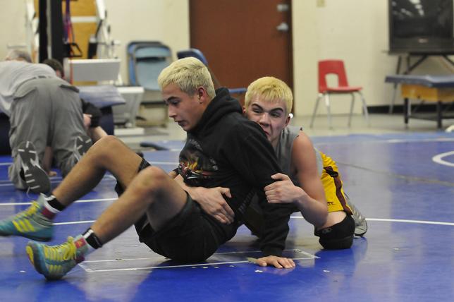 Sophomore Matt Mejia, left, and Alex Casillas practice their holds, escapes and pins in practice Jan. 23. Every Camp Verde High School wrestler dyed their hair blonde to show their solidarity in the face of being down three weight classes for the Sand Devil Classic, which CVHS came back to win Saturday, Jan. 25, at Page High School.