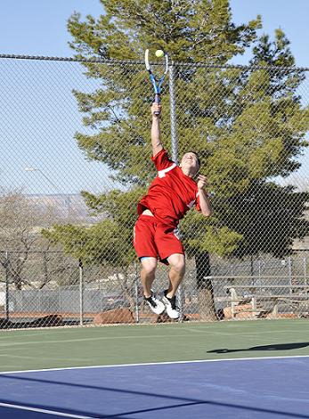 Senior Tanner Caron jumps high to deliver a serve to Sedona Red Rock High School at Mingus Union High School on Tuesday, March 18.