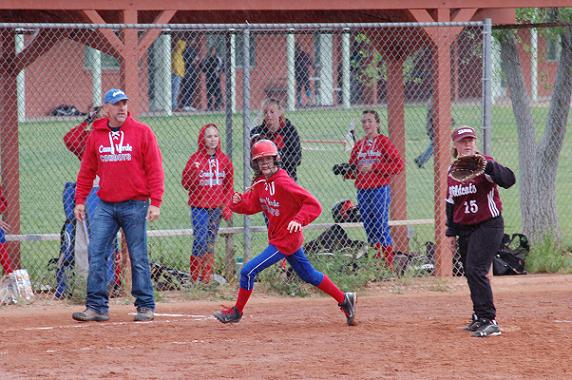 Shortstop Rachel Stockseth, center, a seventh-grader at Camp Verde Middle School, keeps an eye out along with her head coach, Steve Stone, left, for the throw to West Sedona School sixth-grader Christina Schweiss at third base Saturday, April 26, during the Cowboys' semifinal victory over the Wildcats on their way to their fifth Verde Valley Conference championship in five years.