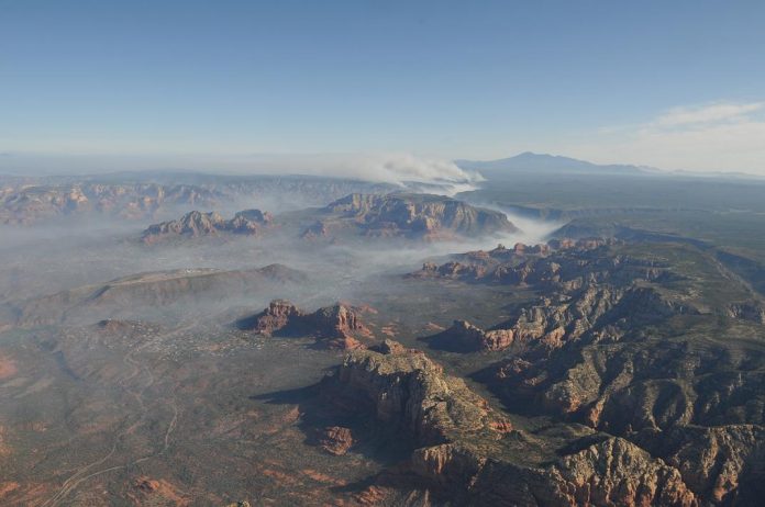 Smoke pours into Sedona through Oak Creek Canyon in the early hours viewed from 11,000 feet above Sedona on Thursday, May 22, in a motorized glider operated by Theodore Grussing of the Village Of Oak Creek. The Slide Fire has consumed apporximately 20,000 acres and still spreading with 35 percent containment.