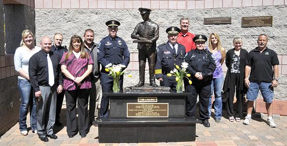 Cottonwood Police Department officers and statue committee members gather Friday, May 16, as The Calling was unveiled, a cast bronze statue honoring those who were killed in the line of duty, as well as active and retired members of the police force.