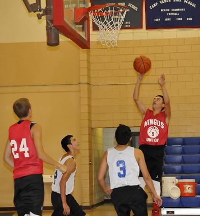 Freshman Jordan Huey, No. 3, and junior Javier Perez harass Mingus Union High School junior guard Evan Snyder as he pulls up for a jump shot June 10 in a scrimmage at Camp Verde High School.