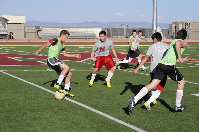 Freshman Wesley Lobaugh, left, tries to pass the ball to junior Kyle Little, third from left, for Camp Verde High School during its first of two boys soccer friendly scrimmages June 13 at Mingus Union High School.