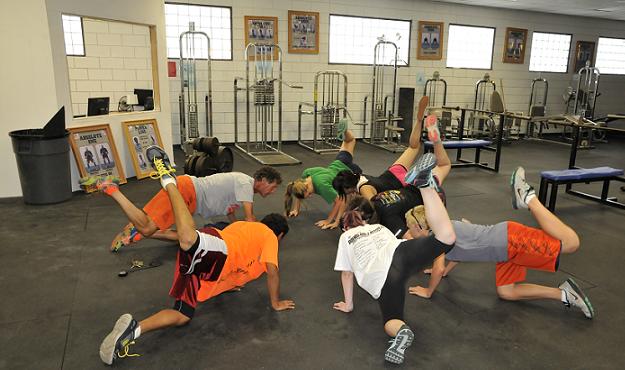 Michael Prow, left, is the new track head coach at Camp Verde High School. Warming up with the Cowboys cross-country team in the weight room, the volunteer assistant to head coach Mike O’Callaghan shows runners how to do such core flexibility exercises as “bird dogs,” “fire hydrants” and “scorpions.”