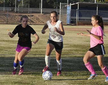 Senior Emma Ehresmann, sophomore Miranda Conway and freshman Alex Schaeffer, from left, practice a keep-away drill in preparation for Camp Verde High School's opening girls soccer state tournament game Thursday, Oct. 30, at Blue Ridge High School.