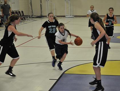 Seventh-grader Anna Peterson dribbles toward the basket and around Big Park Community School defenders. Mountain View Preparatory Academy lost its second game in two tries, 46-16, Tuesday, Nov. 18, to the Coyotes.