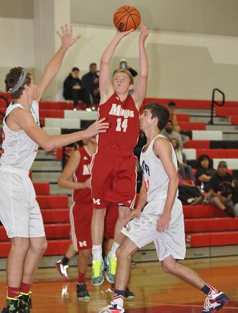Junior Evan Snyder, No. 14, makes a jump shot from the outside, out of the defender's reach Saturday, Nov. 22. The Mingus Union High School boys basketball team scrimmaged Scottsdale Christian Academy.