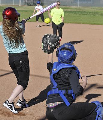 Carlee Oesterreich fires the ball into home plate to catcher Brittney Gunter during a Camp Verde Middle School softball practice, with Jadie Edwards taking her cuts. The Cowboys are 2-0 through the early part of their schedule.