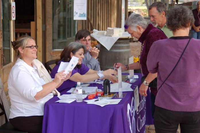 Checking in attendees at the Catholic Charities fundraiser April 10 at the Mongini Barn in Cottonwood are Mary McCoy, office manager at The Loft homeless day center in Old Town, Doris Muñiz, administrative assistant, and Dennis Holt, a volunteer.