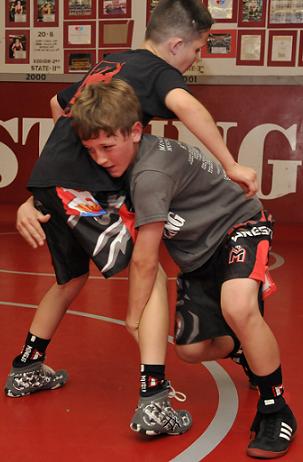 Isaac McKean, right, at 78 pounds, executes a move taught by his father, Mingus Mountain Wrestling Club head coach Klint McKean, on fellow fifth-grader Avery Romero at the Mingus Union High School wrestling room. Isaac McKean finished runner-up in his weight class at the Terminator World Championships in March and will be attending a Grand Canyon University camp, which begins Tuesday, May 26