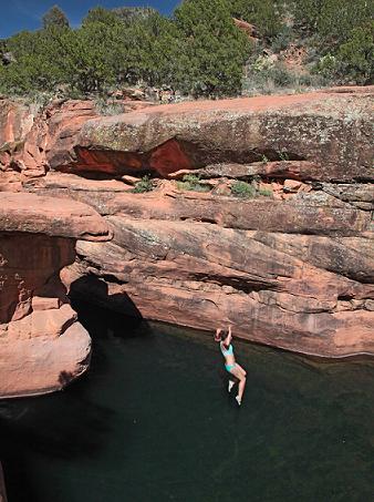 Tamara Miller jumps off the natural diving board in the large swimming hole “The Crack,” which is four miles into the Cave Trail along Wet Beaver Creek off Forest Road 618. The parking lot is located by the East Beaver Creek Ranger Station.