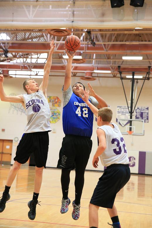 reyes herrera, a junior forward for Camp Verde High School, floats a shot in the paint over Sedona Red Rock High School junior post Walker Cox. Herrera has developed this summer into a primary big man in the paint for head boys basketball coach Dan Wall.