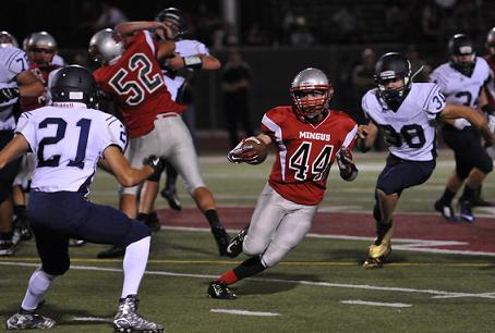 Senior Tristan Clark breaks through the line and into the secondary during Mingus Union High School’s 42-15 season-opening win Friday, Aug. 21, against visiting Cactus Shadows High School at Bright Field. Clark carried the football eight times for 106 yards and a touchdown.