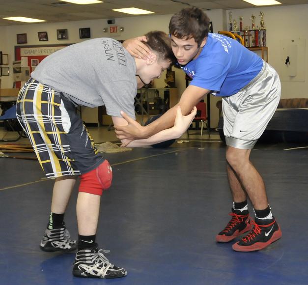 Senior Matt mejia, right, spars for Camp Verde High School with Camp Verde Middle School wrestler Korben Uhler in preparation for the Division IV state tournament. Mejia and Uhler’s older brother, junior Hayden Uhler, won individual titles but the Cowboys could not win their fourth state title in a row, finishing fifth behind champion Safford High School.