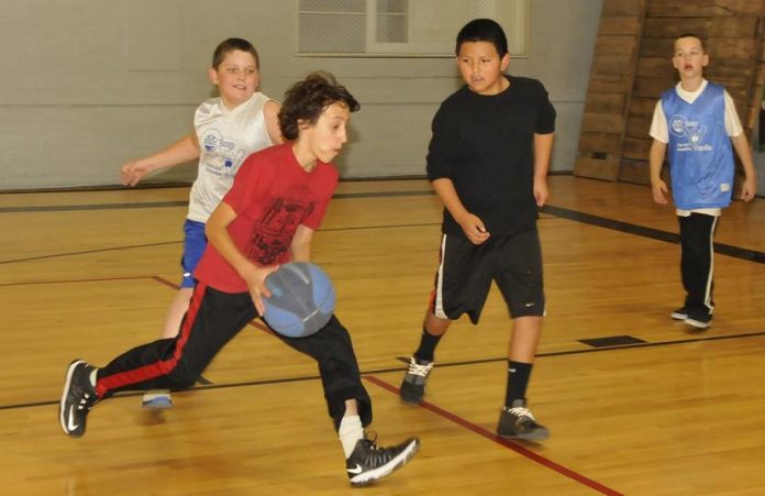 Alex Dale, center, goes for the basket as his teammates simulate an opposing defense. The Dragons lost to Lil TCB in the semifinals of the fifth- and sixth-grade Grasshopper youth basketball league.