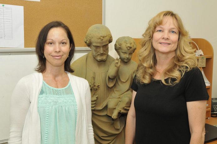 Jill Barteau, left, and Jackie Kirkham stand together in front of a statue of St. Joseph. Barteau is the new preschool director at St. Joseph’s Catholic School, and Kirkham is the new principal. The school itself will soon be renamed to Immaculate Conception Catholic School, to match the parish it sits next to.