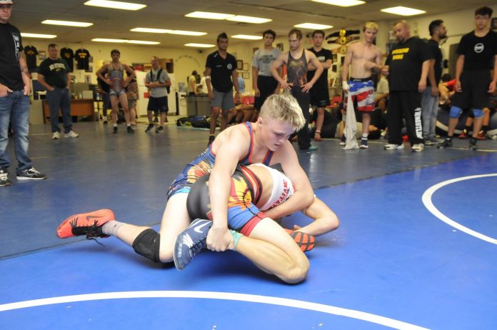 Korbin Uhler, of Camp Verde’s New Breed wrestling team, puts a hold on Austin Blomquist of Yuma during a match at Weekend Wars [above]. The ongoing competition, held in the Camp Verde Wrestling Complex every other weekend through the summer. Wrestlers from across the Southwest come to hone their skills for the regular season.