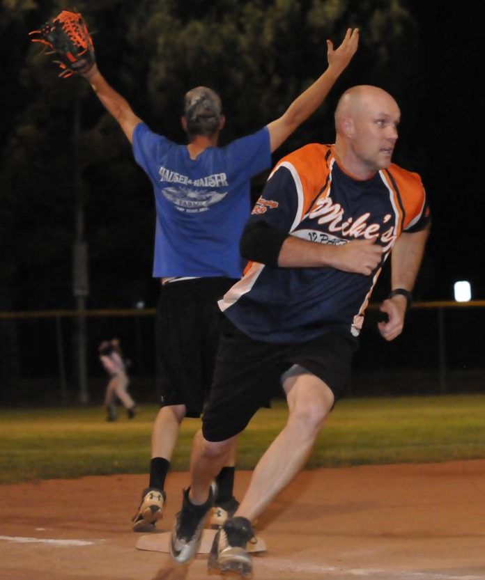 Nate Welly rounds third on his way to scoring a run for Mike’s 12 Pack as Diablos third baseman Easton Bright calls for the throw from the outfield. Mike’s dominated the game, 20-6, to win the championship.